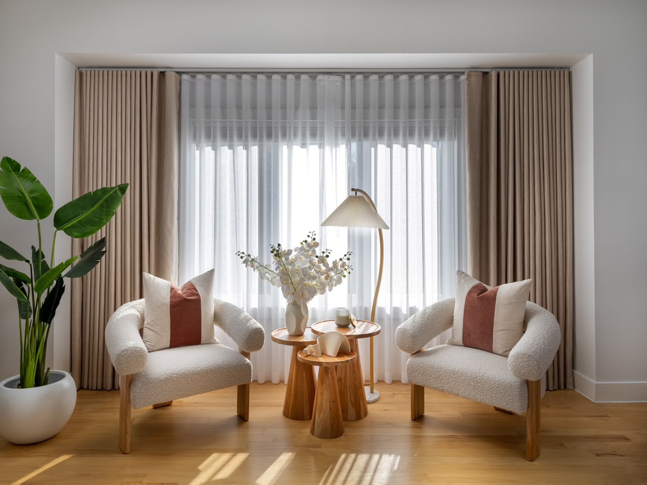 Beige Vorhänge mit weissem Store in einem hellen Wohnzimmer